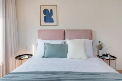 a bedroom with a bed with white and blue pillows at Monastiraki Living Flats by UPSTREET in Athens