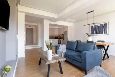 a living room with a blue couch and a table at Monastiraki Living Flats by UPSTREET in Athens