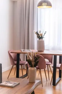 a dining room table with two chairs and a vase with flowers at Monastiraki Living Flats by UPSTREET in Athens