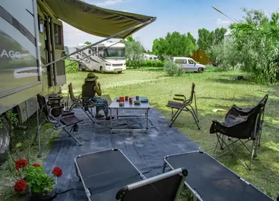 a person sitting at a table with chairs and a bus at Athens Motorhome Park GEORGETOWN RV in Yialoú