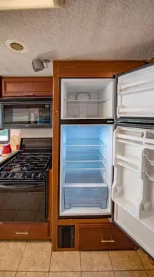 an empty kitchen with an open refrigerator and stove at Athens Motorhome Park GEORGETOWN RV in Yialoú