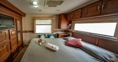 a small room with a bed in a rv at Athens Motorhome Park GEORGETOWN RV in Yialoú