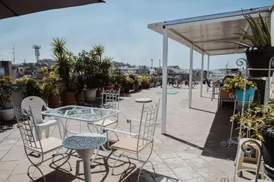 a patio with chairs and a table and a table and chairs at No7 Theo Homeybee Exarcheia in Athens