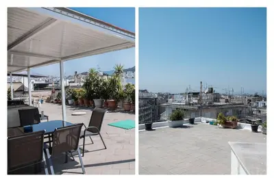 a patio with a table and chairs and an umbrella at No7 Theo Homeybee Exarcheia in Athens