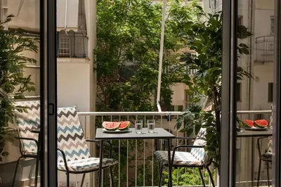 a table and chairs on a balcony with watermelon at Kaf23 - 2BR apt with Balcony in Athens
