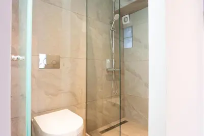 a bathroom with a glass shower with a toilet at The Athenian Penthouse in Syntagma Square in Athens