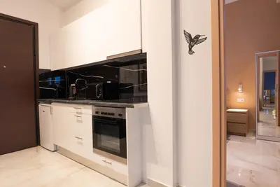 a kitchen with white cabinets and a butterfly on the wall at The Athenian Penthouse in Syntagma Square in Athens