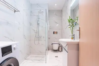 a white bathroom with a shower and a sink at The Athenian Penthouse in Syntagma Square in Athens