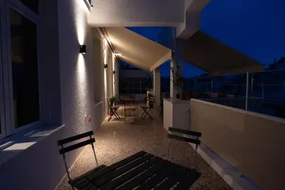 a balcony with a bench on a building at night at The Athenian Penthouse in Syntagma Square in Athens