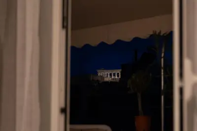 a window view of the white house at night at The Athenian Penthouse in Syntagma Square in Athens