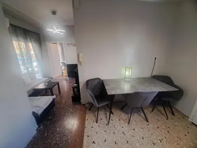 a living room with a table and chairs and a couch at Exarchia Penthouse Cozy & Central in Athens
