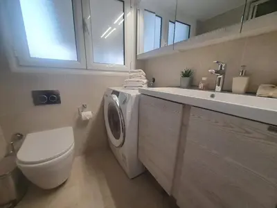 a bathroom with a toilet and a sink and a washing machine at Exarchia Penthouse Cozy & Central in Athens