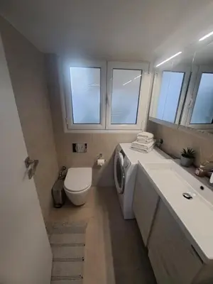 a bathroom with a toilet sink and a washing machine at Exarchia Penthouse Cozy & Central in Athens