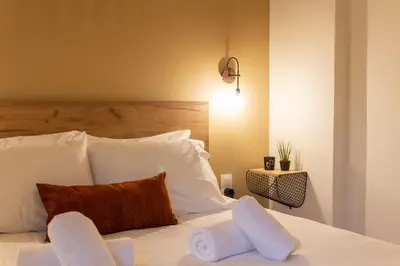 a bedroom with a bed with white sheets and pillows at Serenity Luxury Estates in Piraeus