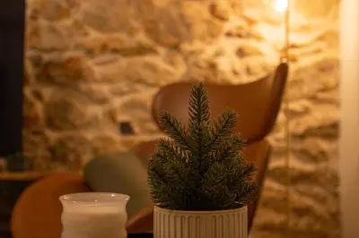 a plant in a white vase next to a candle at Serenity Luxury Estates in Piraeus