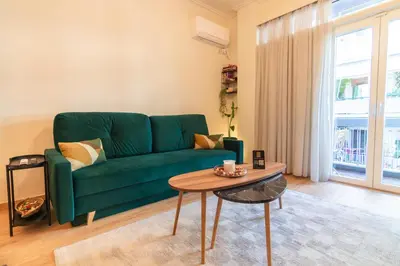 a living room with a green couch and a table at Serenity Luxury Estates in Piraeus