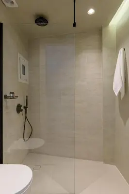 a bathroom with a shower with a glass door at Acropolis Loom Suite in Athens