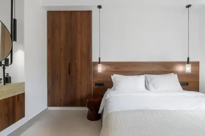 a bedroom with a bed and a wooden headboard at Acropolis Loom Suite in Athens
