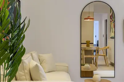 a living room with a couch and a mirror at Acropolis Loom Suite in Athens