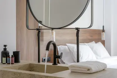 a bathroom sink with a mirror on top of it at Acropolis Loom Suite in Athens