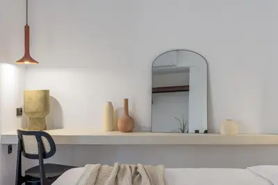 a mirror on a shelf with a chair in a room at Acropolis Loom Suite in Athens