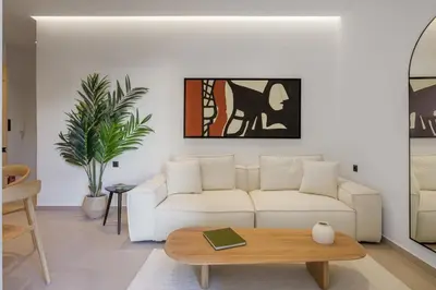 a living room with a white couch and a coffee table at Acropolis Loom Suite in Athens