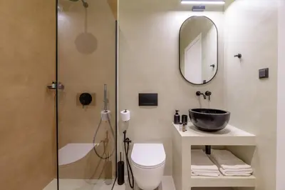 a bathroom with a shower and a toilet and a sink at Acropolis Loom Suite in Athens