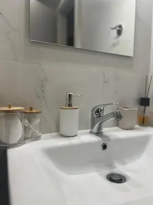 a bathroom sink with two cups and a mirror at Athens Hotspot Residence in Athens