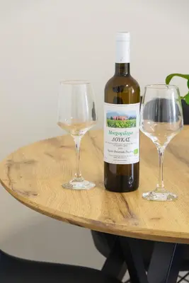 a bottle of wine and two glasses on a table at Entire, spacious, spotless apartment, in Ilioupoli, Greece in Athens