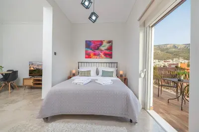 a white bedroom with a bed and a balcony at Entire, spacious, spotless apartment, in Ilioupoli, Greece in Athens
