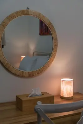 a mirror on a wall next to a table with a lamp at Entire, spacious, spotless apartment, in Ilioupoli, Greece in Athens