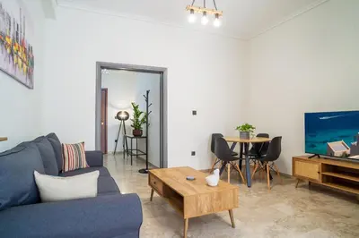 a living room with a blue couch and a table at Entire, spacious, spotless apartment, in Ilioupoli, Greece in Athens