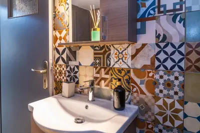 a bathroom with a sink and colorful tiles at Entire, spacious, spotless apartment, in Ilioupoli, Greece in Athens