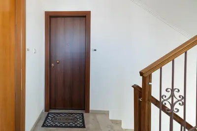 a hallway with a wooden door and stairs at Entire, spacious, spotless apartment, in Ilioupoli, Greece in Athens