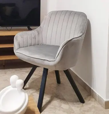 a gray chair sitting in front of a tv at Entire, spacious, spotless apartment, in Ilioupoli, Greece in Athens