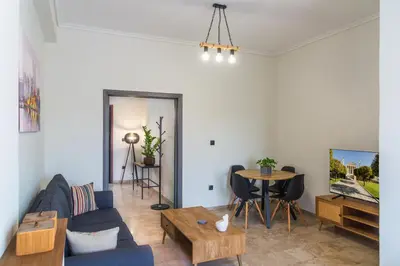 a living room with a blue couch and a table at Entire, spacious, spotless apartment, in Ilioupoli, Greece in Athens