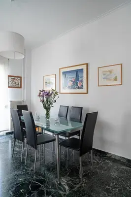 a dining room with a glass table and chairs at Florou's art-gallery apartment, Kypseli in Athens