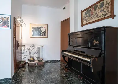 a black piano in a room with a wall at Florou's art-gallery apartment, Kypseli in Athens