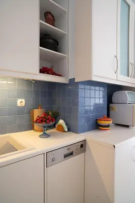 a kitchen with white cabinets and a bowl of fruit at Florou's art-gallery apartment, Kypseli in Athens
