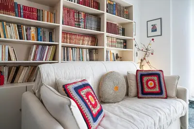 a white couch with two pillows on it in a living room at Florou's art-gallery apartment, Kypseli in Athens
