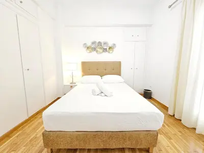 a white bedroom with a large bed with white sheets at Athens Belvedere Palace in Athens
