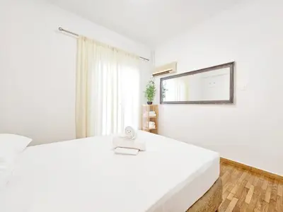 a white bedroom with a white bed and a window at Athens Belvedere Palace in Athens