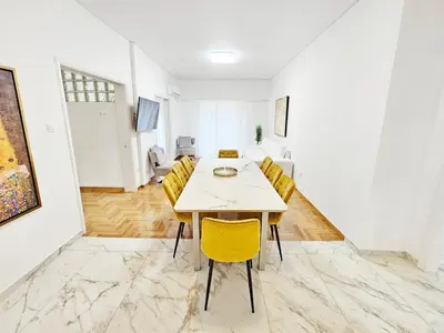 a dining room with a table and yellow chairs at Athens Belvedere Palace in Athens