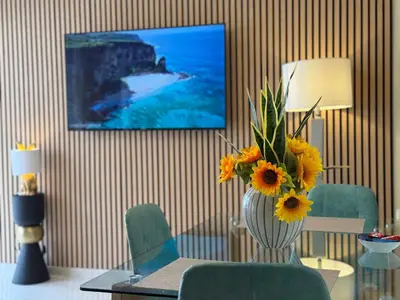 a living room with a vase of sunflowers on a table at Acropolis Calm Escape-Central 2 min from the metro in Athens