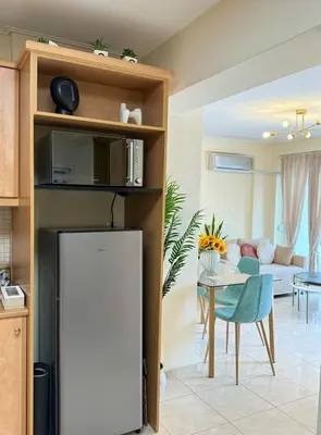 a kitchen and living room with a refrigerator and a table at Acropolis Calm Escape-Central 2 min from the metro in Athens