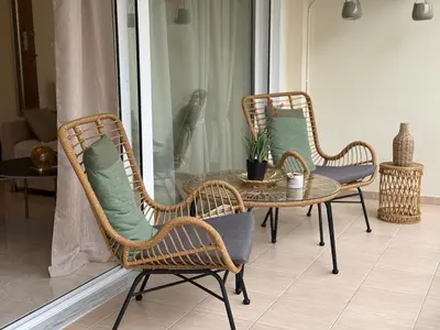 three wicker chairs and a table and a table and chairs at Acropolis Calm Escape-Central 2 min from the metro in Athens