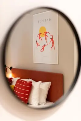 a mirror reflection of a bed with a painting on the wall at Praxitelous Hideout in Athens