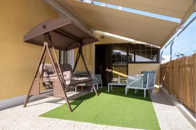 a porch with a hammock and chairs on a patio at Comfortable two bedroom Athens appartment - Sando in Athens