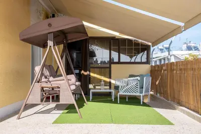 a porch with a hammock and chairs on a patio at Comfortable two bedroom Athens appartment - Sando in Athens