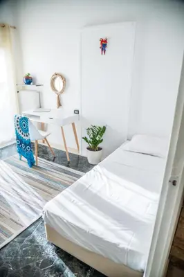 a bedroom with a bed and a table and a chair at Comfortable two bedroom Athens appartment - Sando in Athens